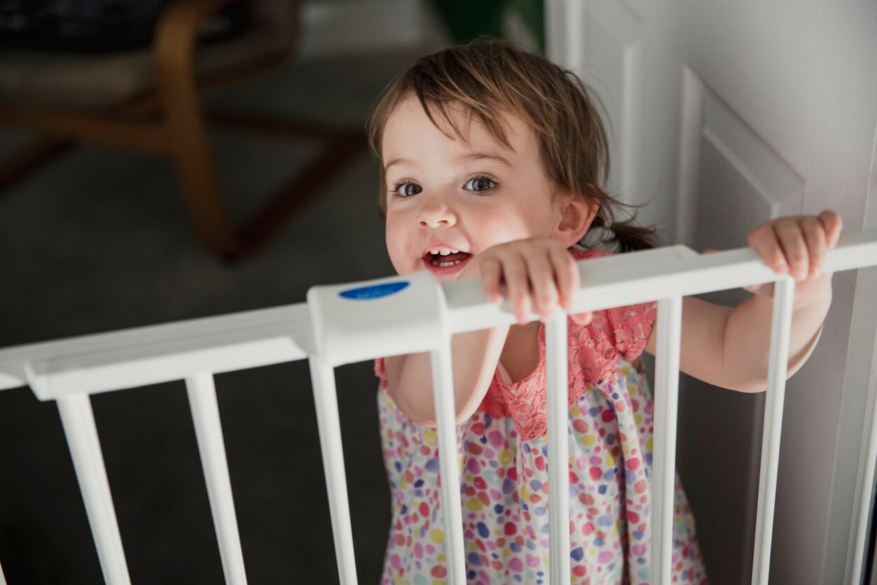 baby standing behind baby gate